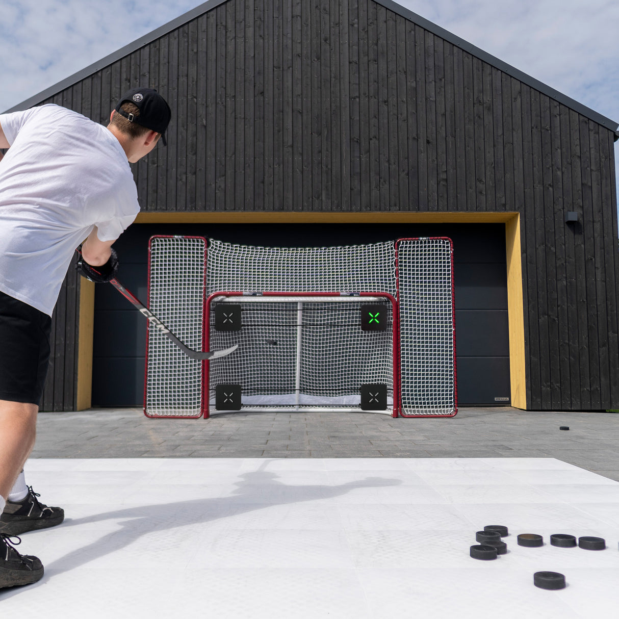 Person playing hockey on an outdoor rink with a goal in the background.