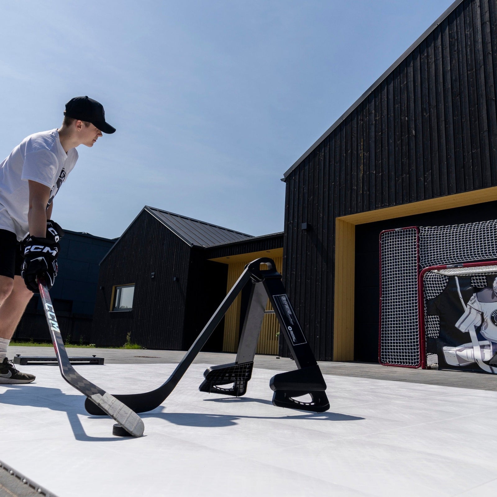 Hockey player toe-dragging a puck under a Pro Defender obstacle on a backyard rink