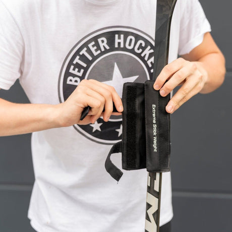 Hockey player attaching an Extreme stick weight to the shaft to build full-body shot power