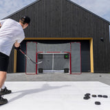 Person playing hockey on an outdoor rink with a goal in the background.